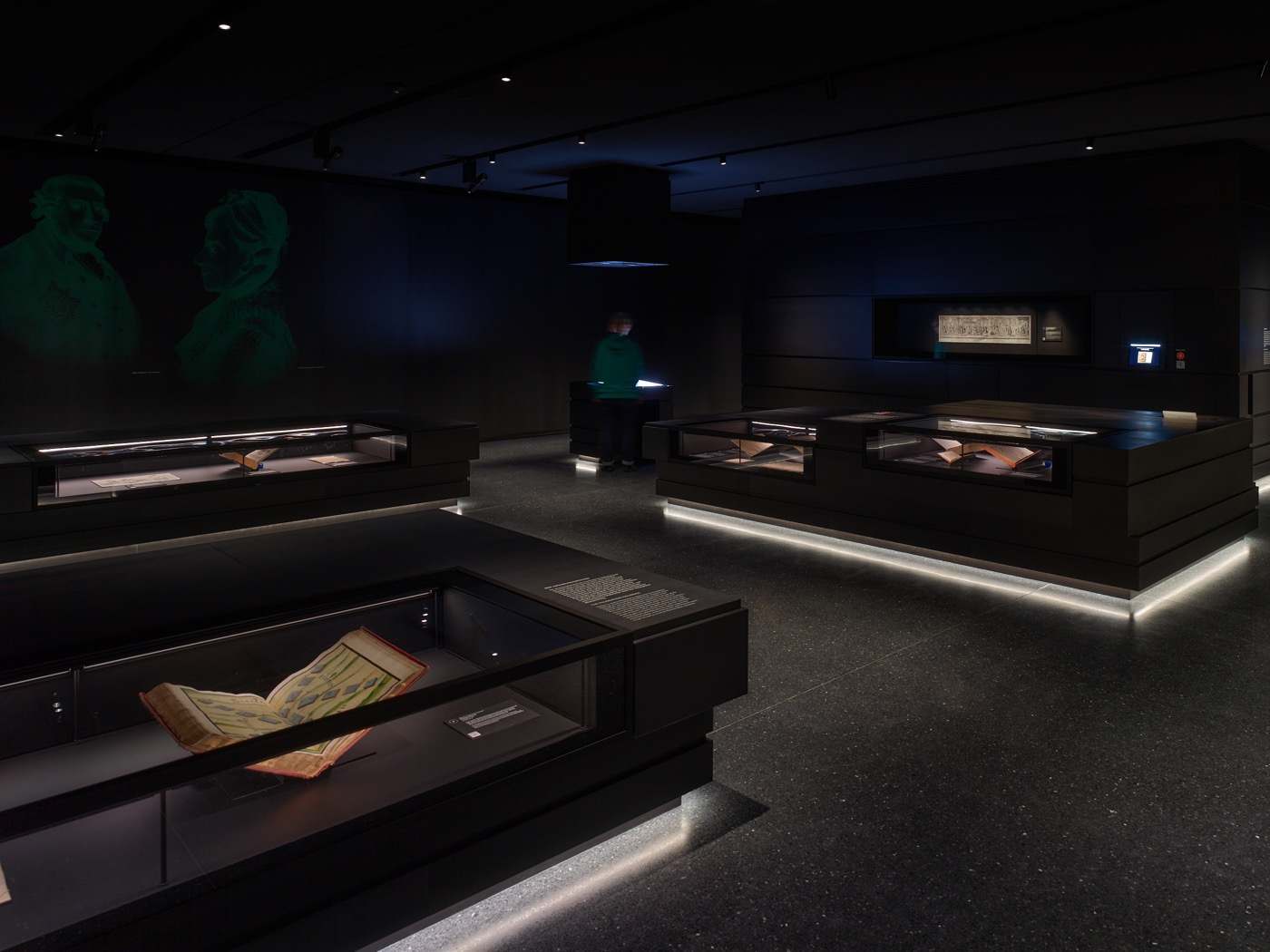 Dauerausstellungsbereich im Stabi-Kulturwerk im Zugangsbereich mit schwarzen Tischvitrinen, unterleuchtet und mit integrierter Beleuchtung, Wandvitrinen und Medienstation